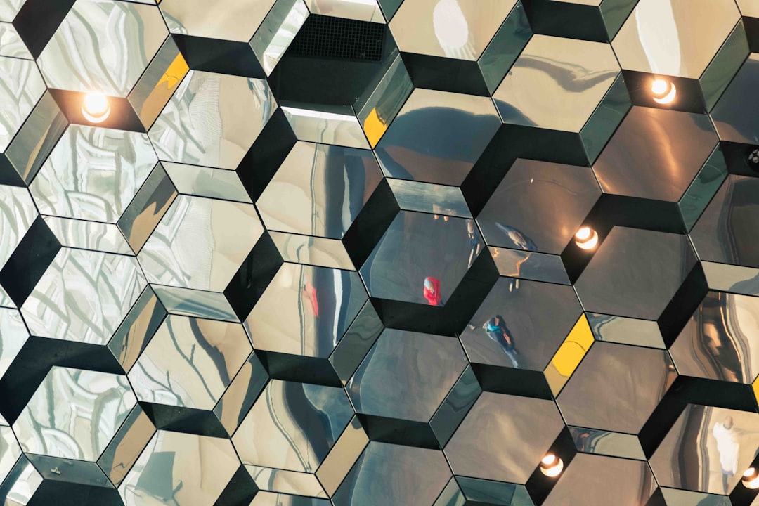 The Harpa Concert Halls honeycomb glass panels create an abstract mosaic of light and reflection. This close-up captures the essence of the buildings creative design, where each panel acts as a fragment of a larger, dynamic composition, playing with the interior light and the reflections of the world outside.